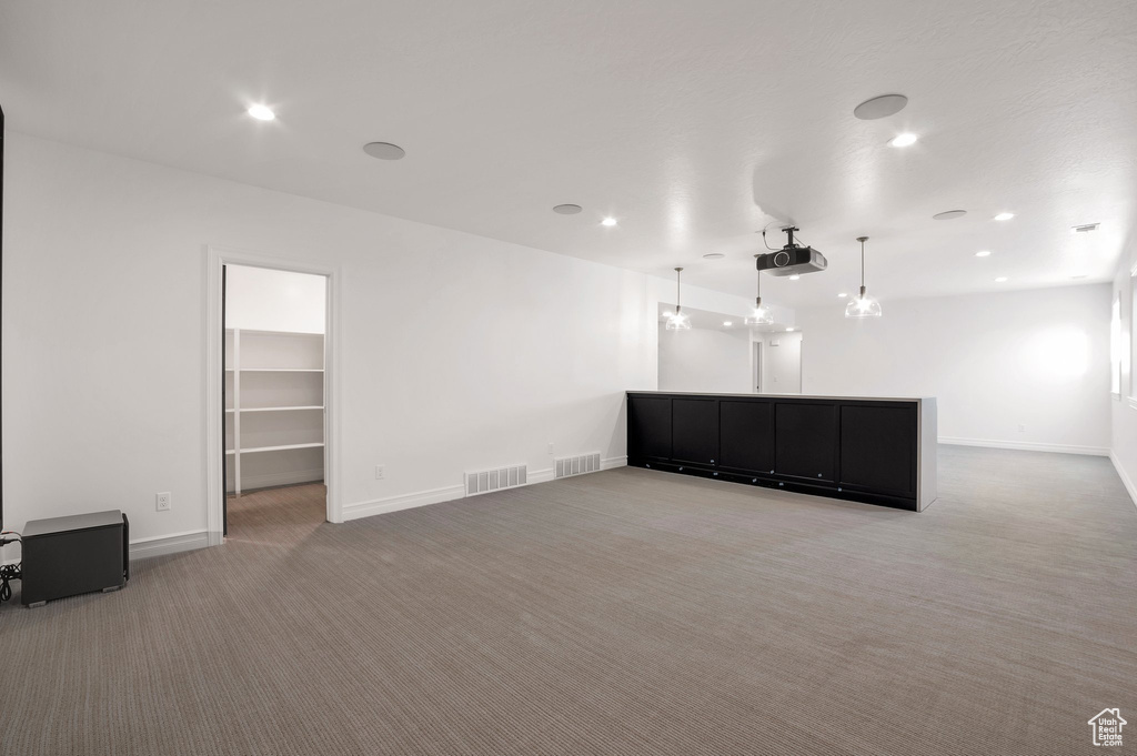 Unfurnished living room featuring carpet, baseboards, and recessed lighting