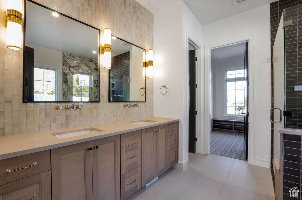 Bathroom with double vanity, a stall shower, and tile patterned flooring