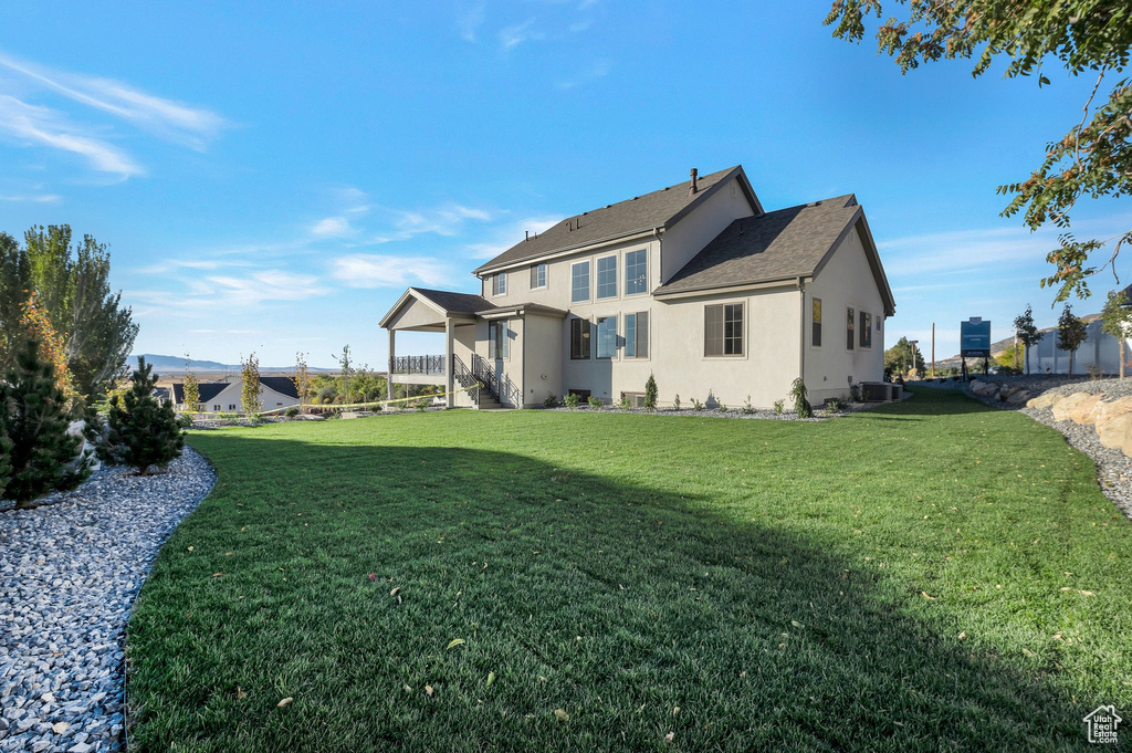 Rear view of property featuring stucco siding and a yard