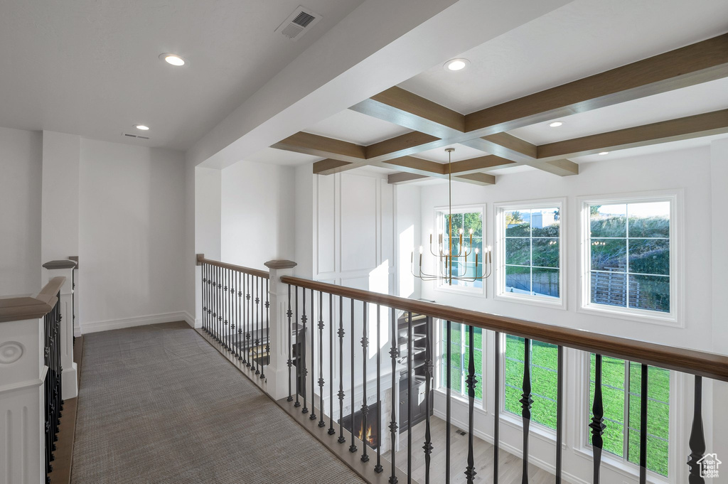 Hallway with beamed ceiling, recessed lighting, coffered ceiling, a chandelier, and carpet floors