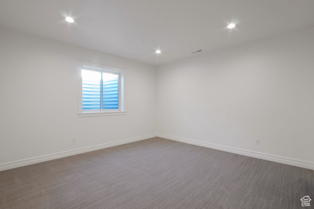 Empty room with recessed lighting, baseboards, and dark colored carpet