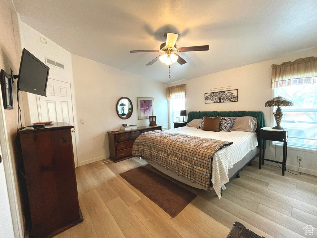 Bedroom with light wood-type flooring, baseboards, ceiling fan, and lofted ceiling