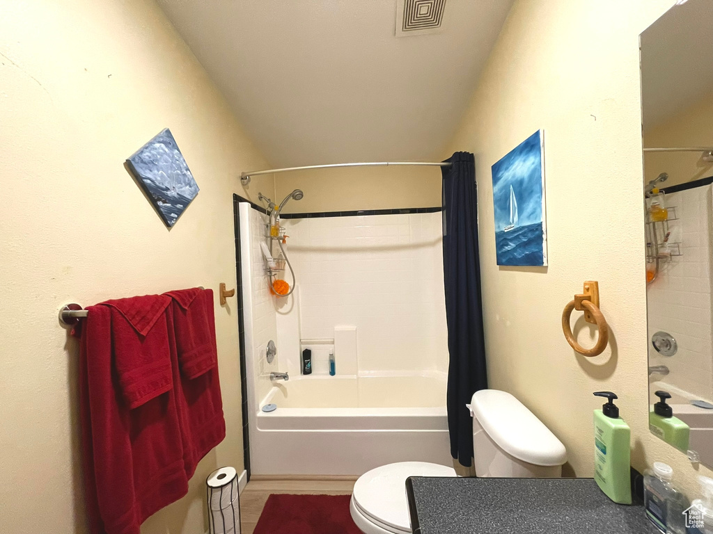 Bathroom featuring toilet, shower / tub combo, and tile patterned floors