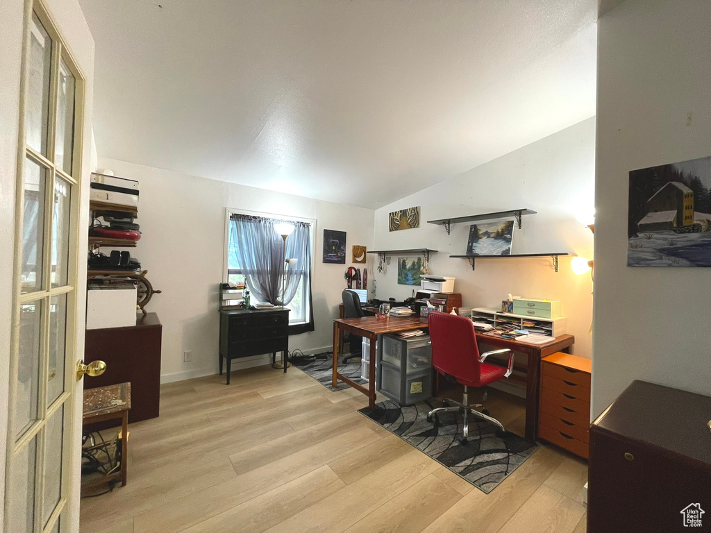 Office space featuring light wood finished floors and lofted ceiling