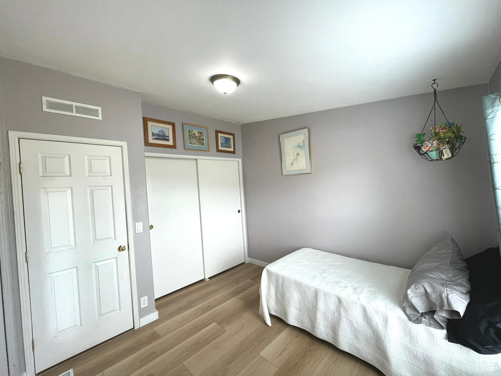 Bedroom featuring wood finished floors, baseboards, and a closet