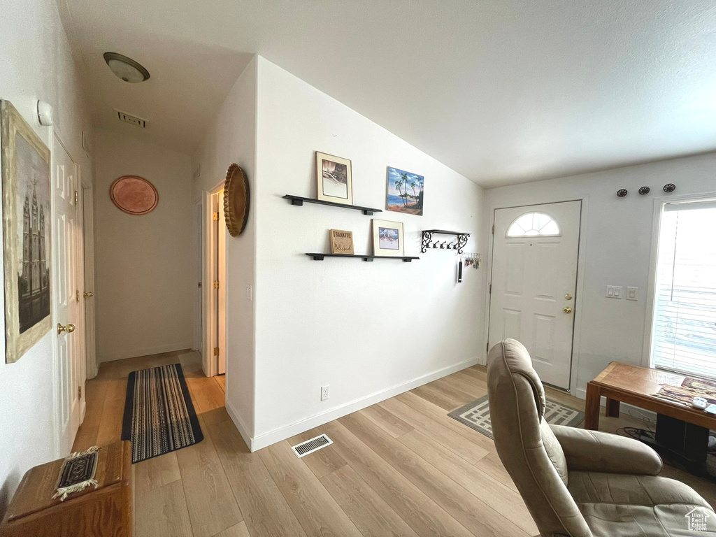 Foyer featuring lofted ceiling and light wood-type flooring