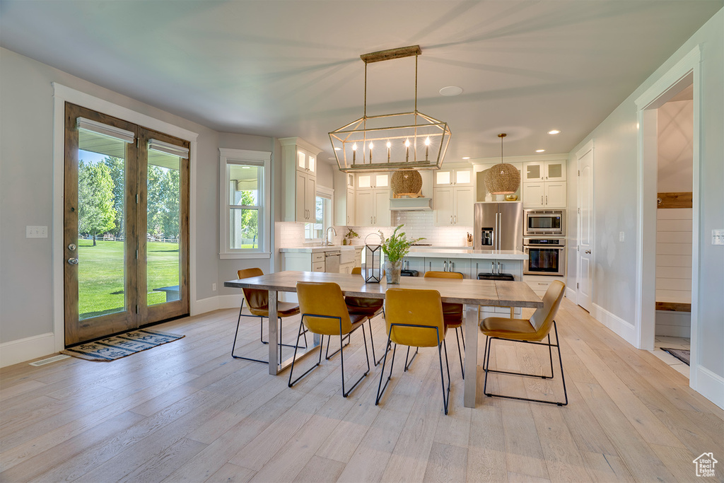 Dining space with light wood-type flooring, baseboards, and recessed lighting