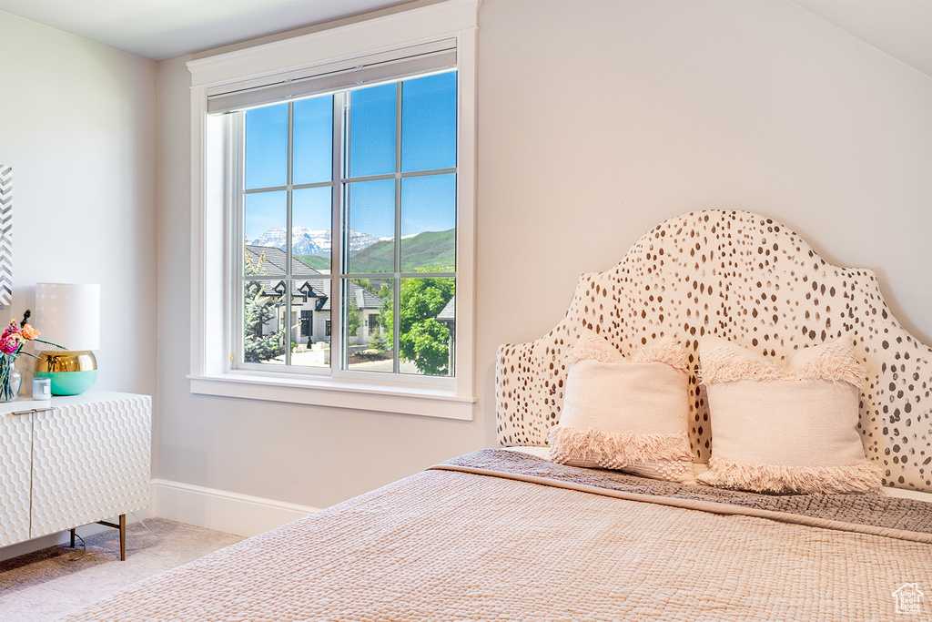 Bedroom featuring multiple windows, carpet floors, baseboards, and a mountain view