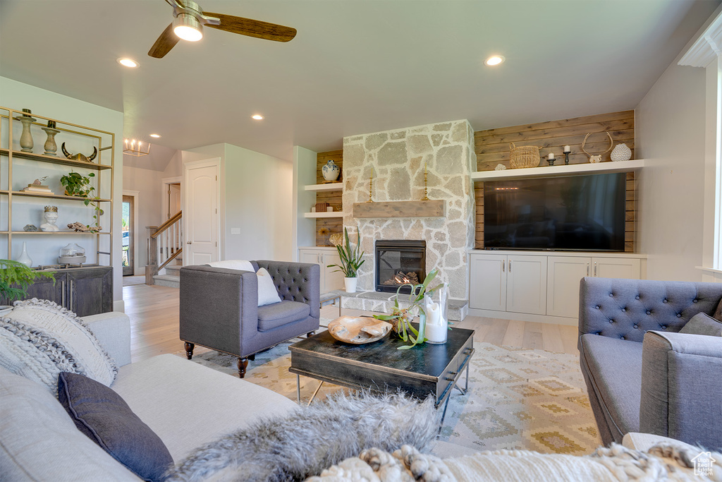Living area with a fireplace, light wood-style floors, stairway, ceiling fan, and recessed lighting