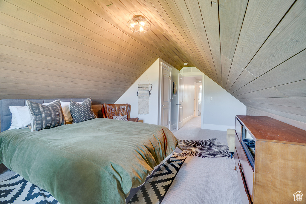 Bedroom featuring vaulted ceiling, carpet flooring, and wood ceiling