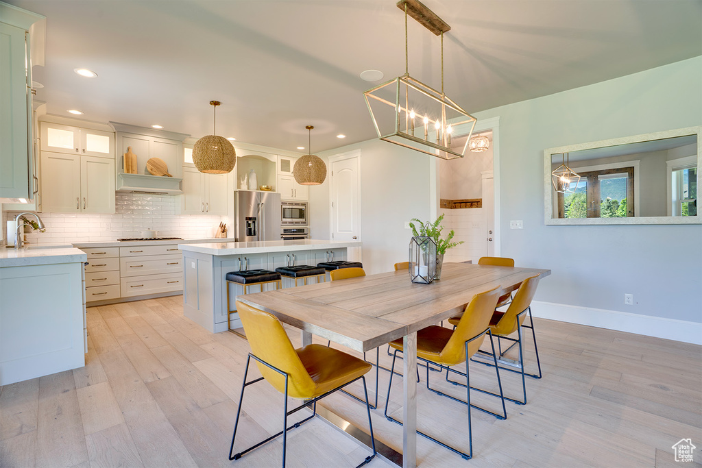 Dining area with light wood-type flooring, recessed lighting, baseboards, and a chandelier