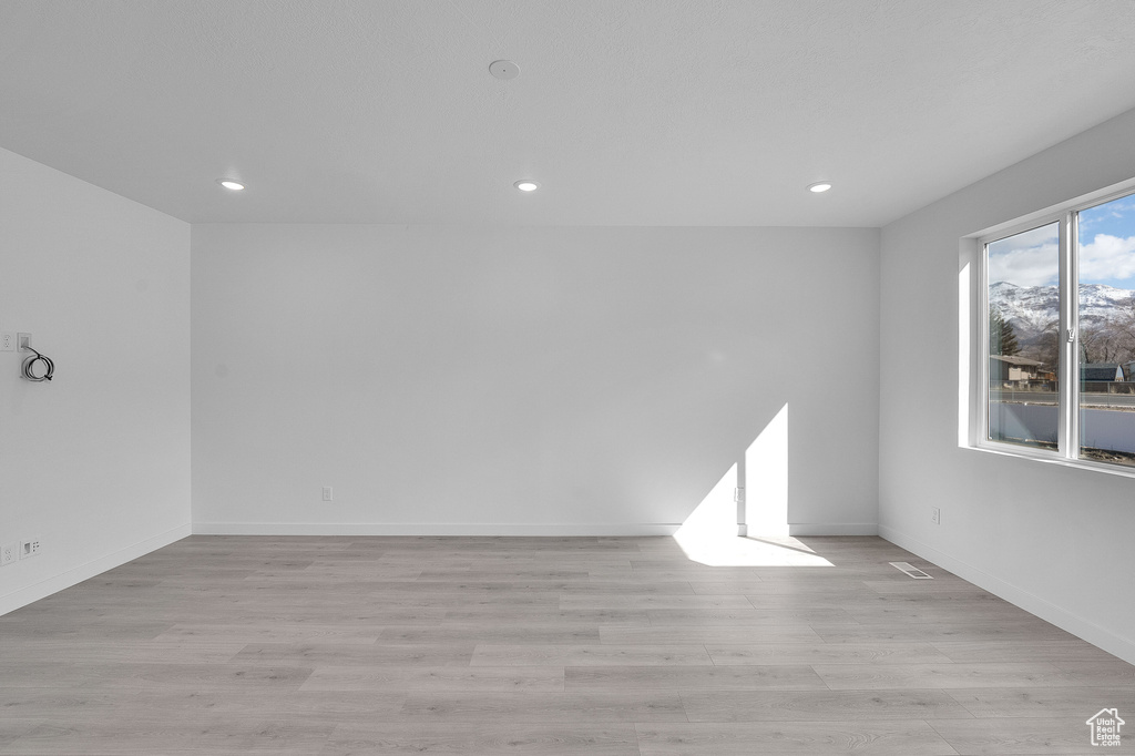 Spare room with recessed lighting, light wood-style flooring, and baseboards