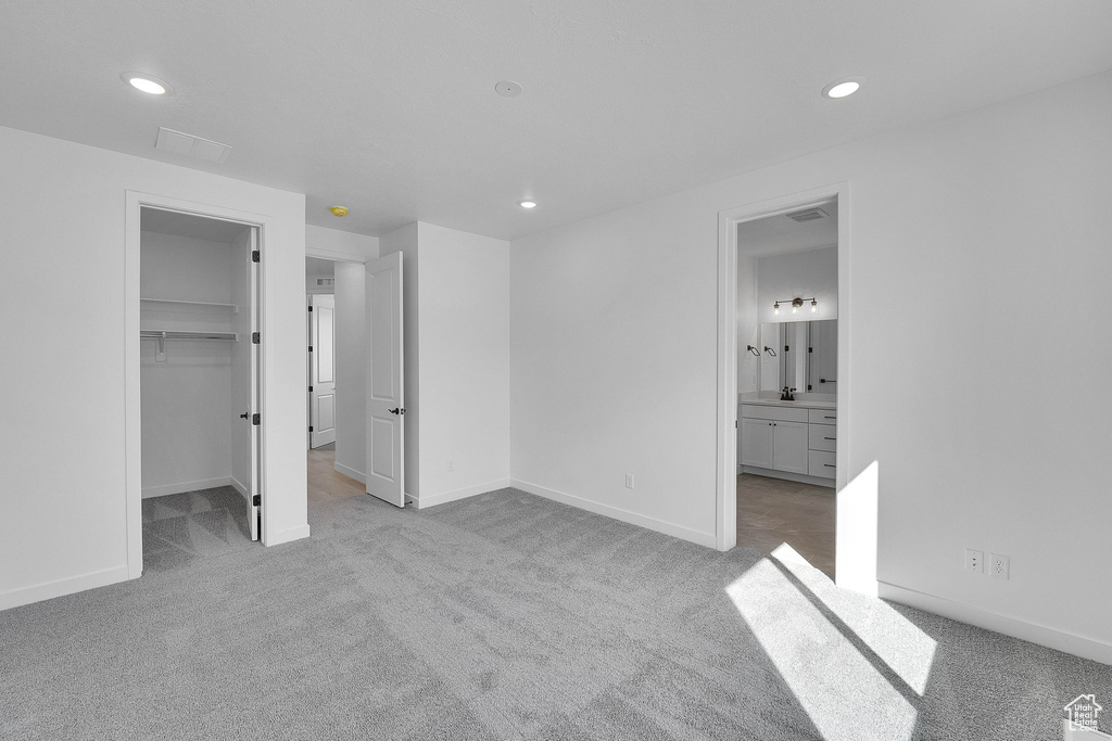 Unfurnished bedroom featuring carpet flooring, recessed lighting, a spacious closet, and baseboards