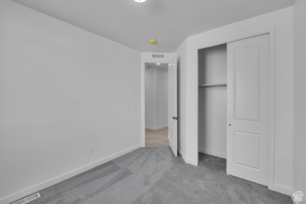 Unfurnished bedroom with carpet flooring, baseboards, and a closet