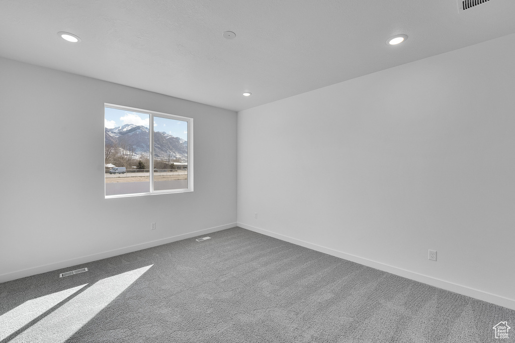 Carpeted empty room featuring recessed lighting and baseboards
