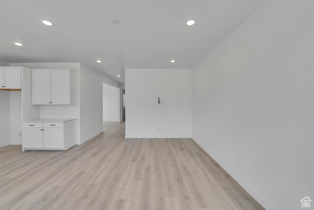 Unfurnished living room featuring recessed lighting, baseboards, and light wood-style floors