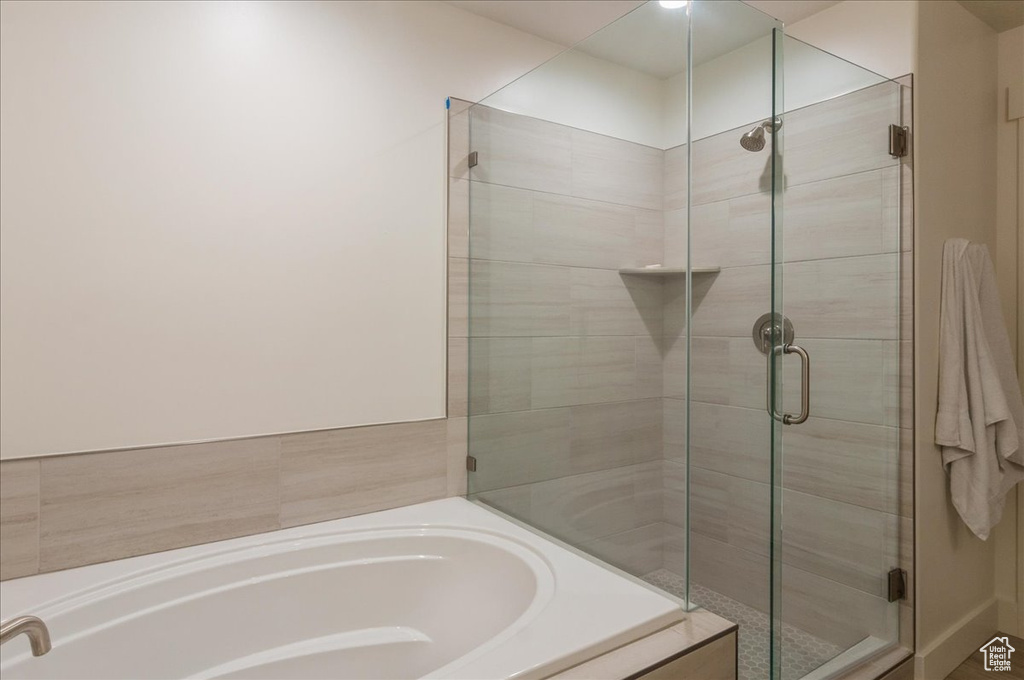 Bathroom featuring a stall shower and a bath