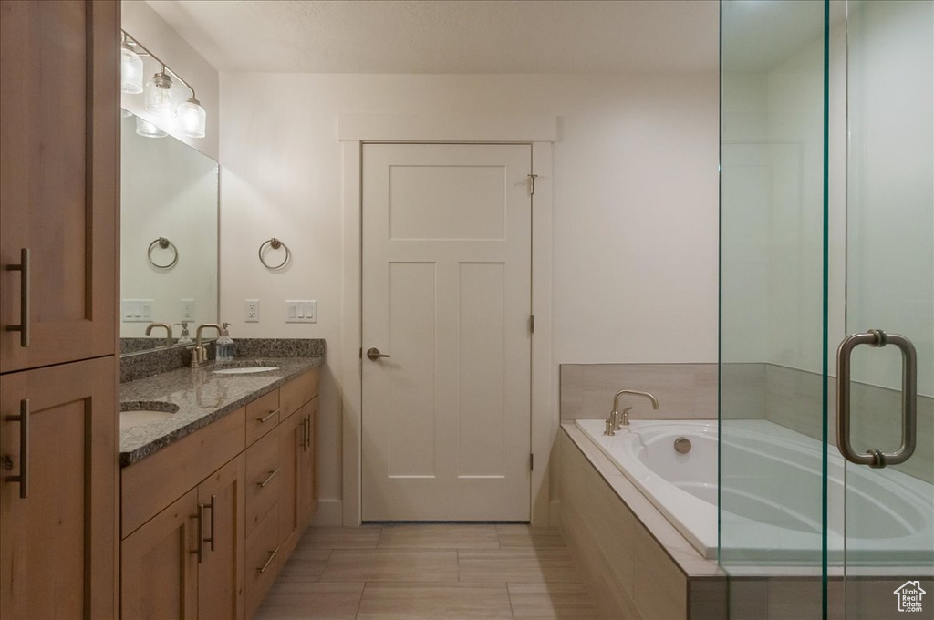 Full bath featuring double vanity and a garden tub