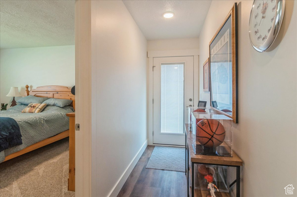 Entryway featuring baseboards, wood finished floors, and a textured ceiling