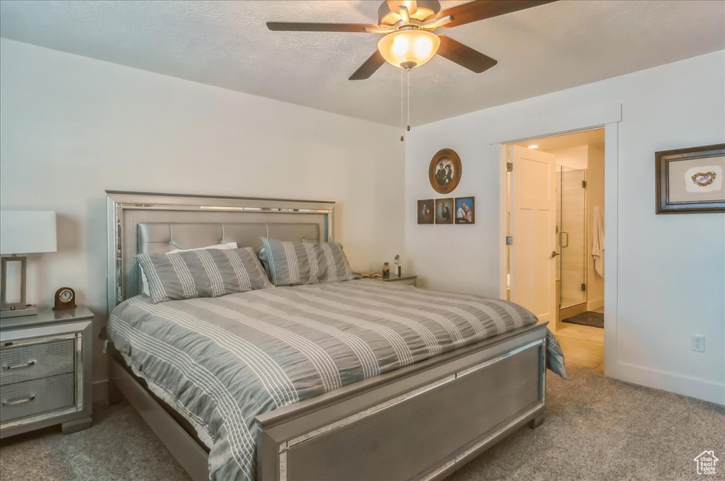 Bedroom featuring carpet floors, ensuite bath, a ceiling fan, and baseboards