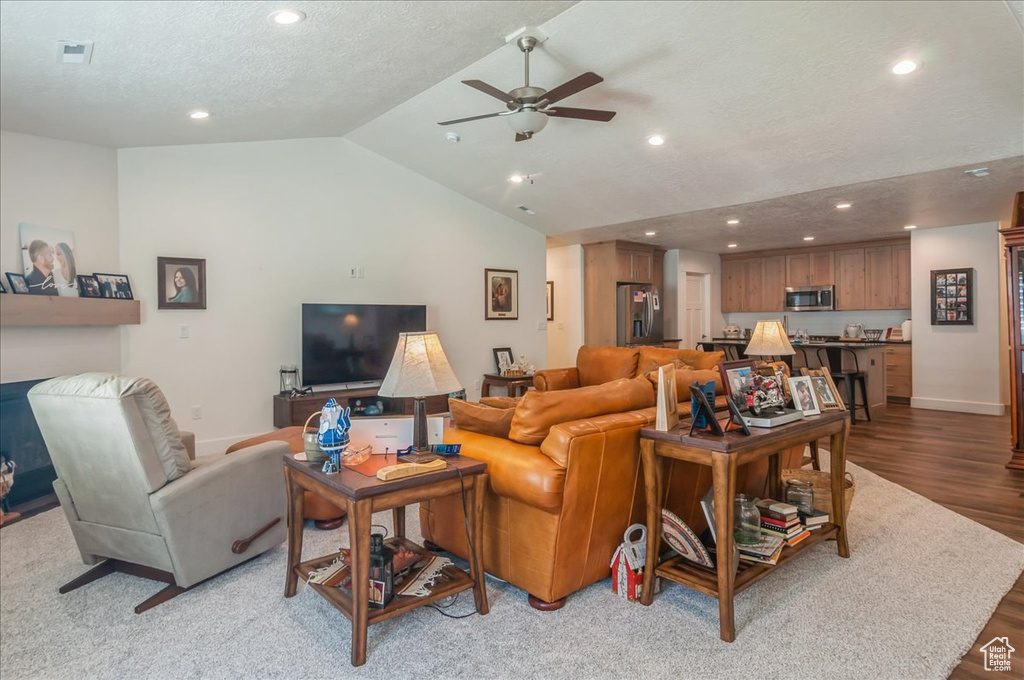 Living area with recessed lighting, a ceiling fan, vaulted ceiling, wood finished floors, and baseboards