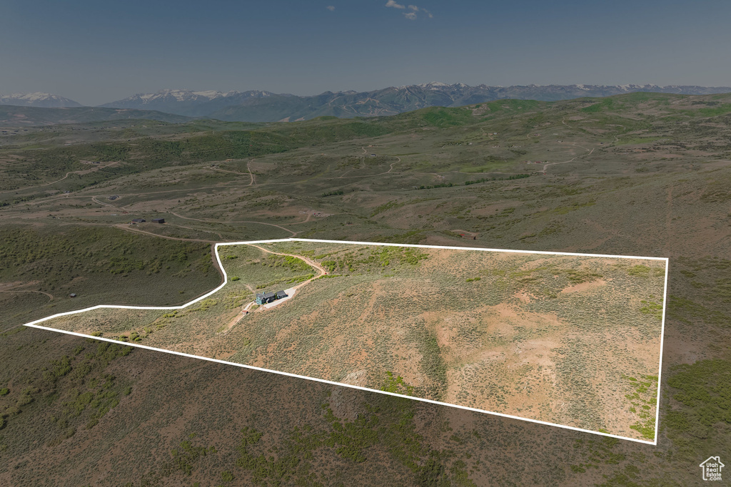 Aerial view of sparsely populated area featuring property parcel outlined and a mountain backdrop