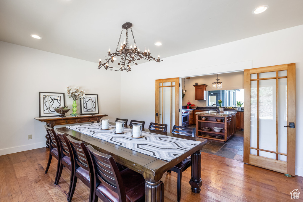 Dining space featuring a chandelier, dark wood-type flooring, baseboards, and recessed lighting