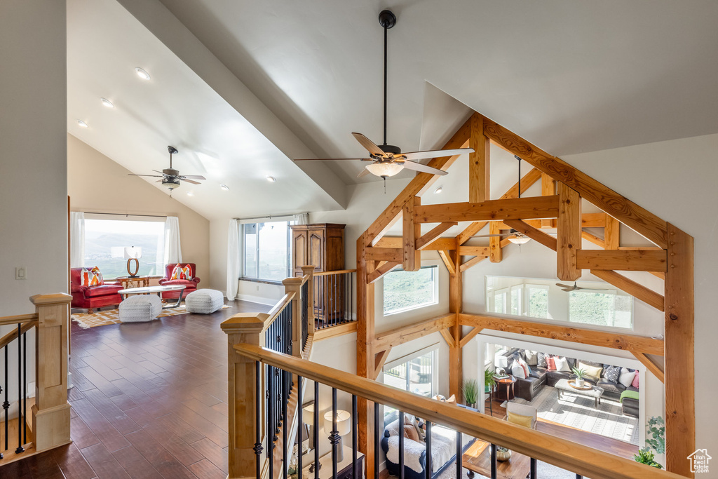 Hall with an upstairs landing, lofted ceiling, and dark wood-type flooring