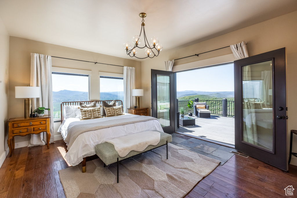 Bedroom with access to exterior, a chandelier, a mountain view, and hardwood / wood-style floors