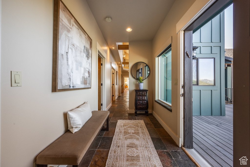Hallway featuring stone tile flooring, recessed lighting, and baseboards