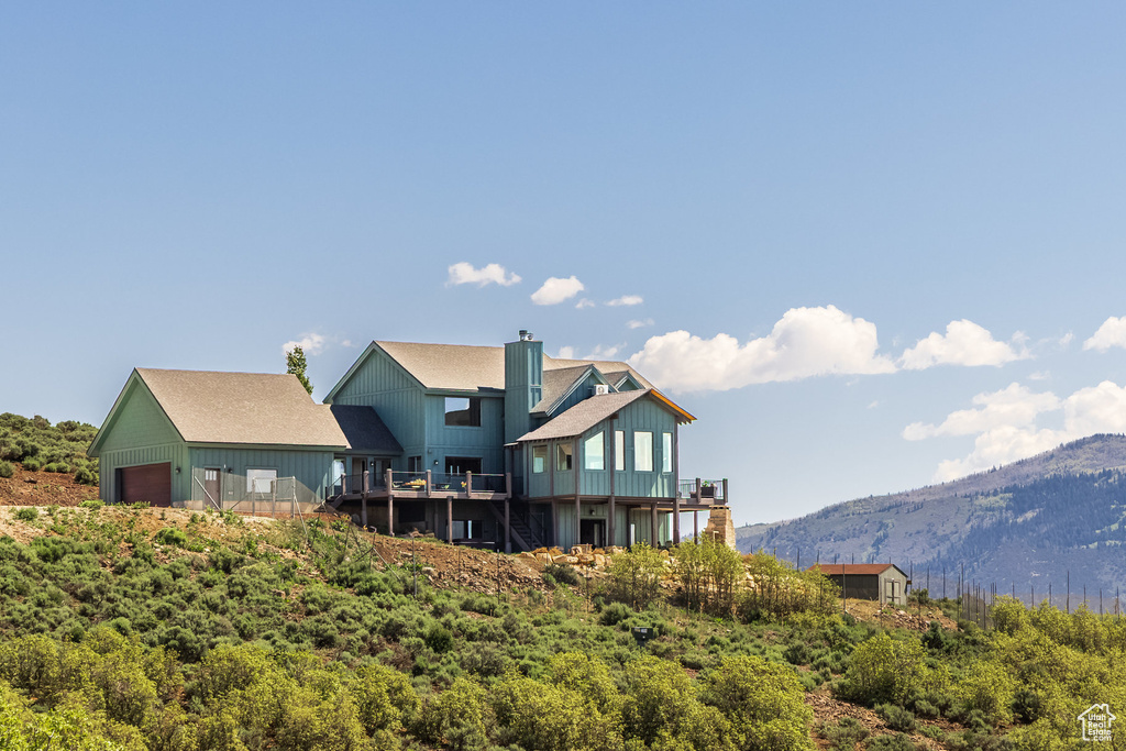 Rear view of house with a mountain view and a chimney