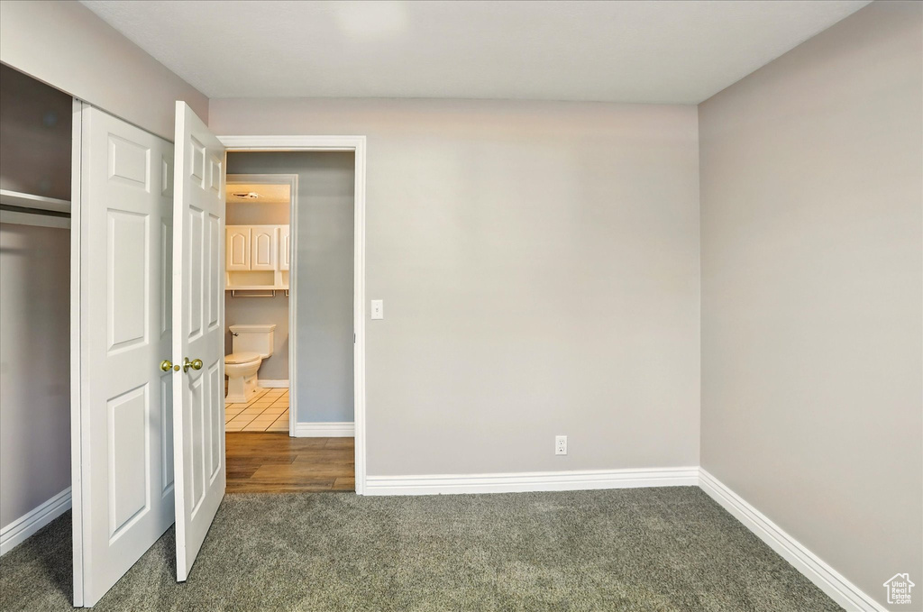 Unfurnished bedroom with carpet flooring, baseboards, and a closet