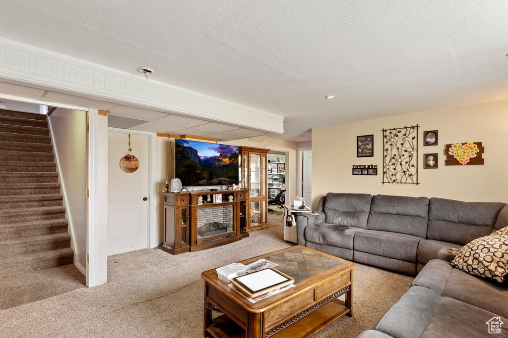 Carpeted living area featuring stairs