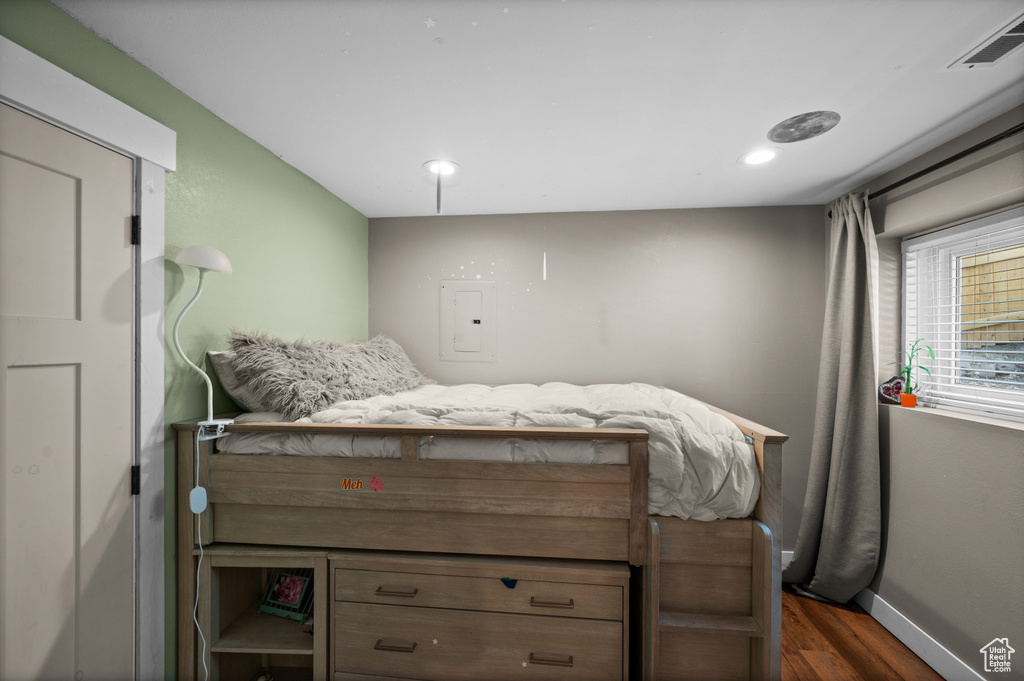 Bedroom featuring dark wood-style floors, baseboards, electric panel, and recessed lighting
