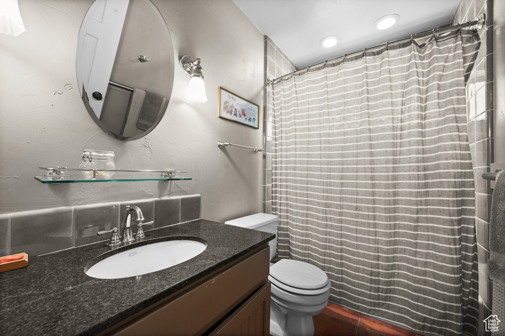 Bathroom featuring toilet, vanity, and a shower with shower curtain
