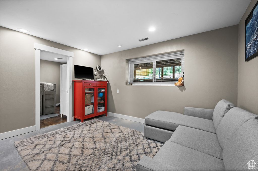 Living area featuring concrete flooring, recessed lighting, and baseboards