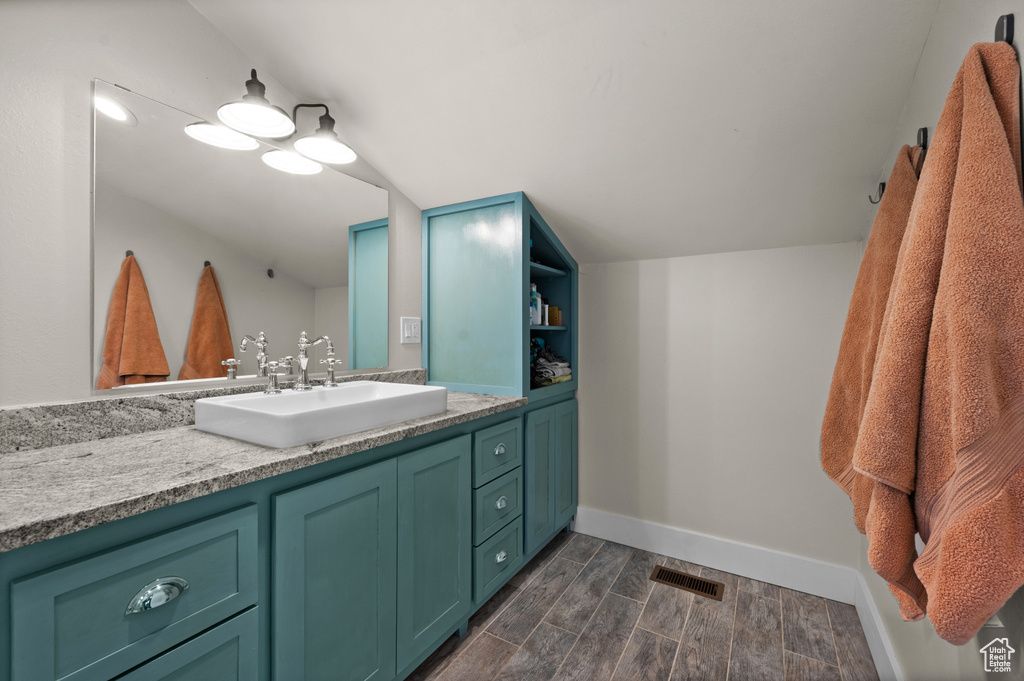 Bathroom with wood finished floors, vanity, and baseboards