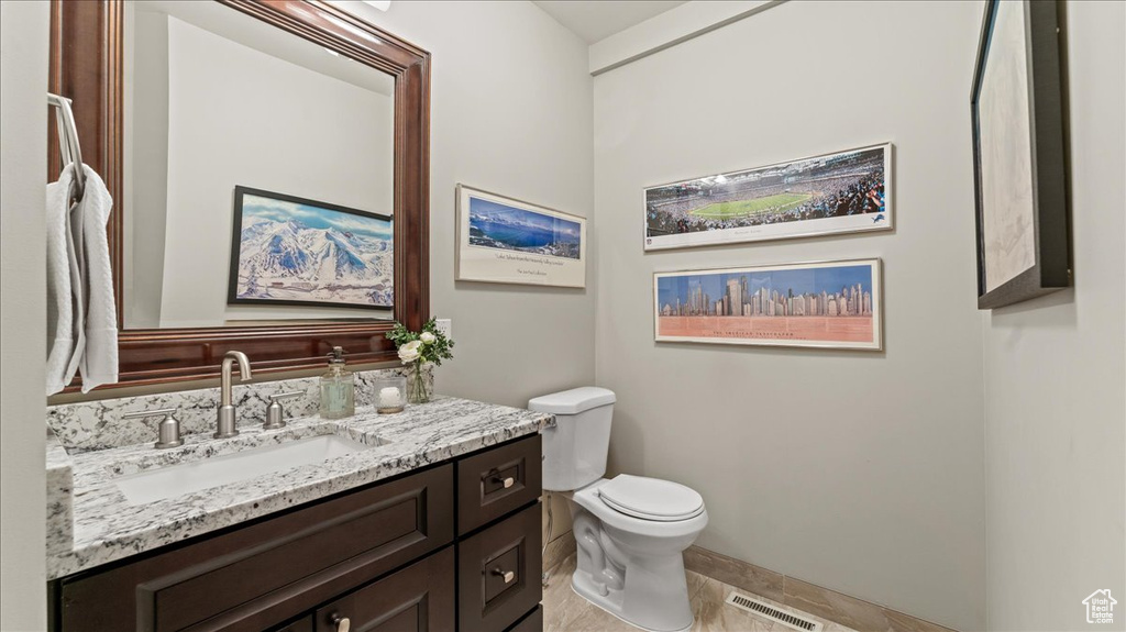 Bathroom featuring toilet, vanity, and baseboards