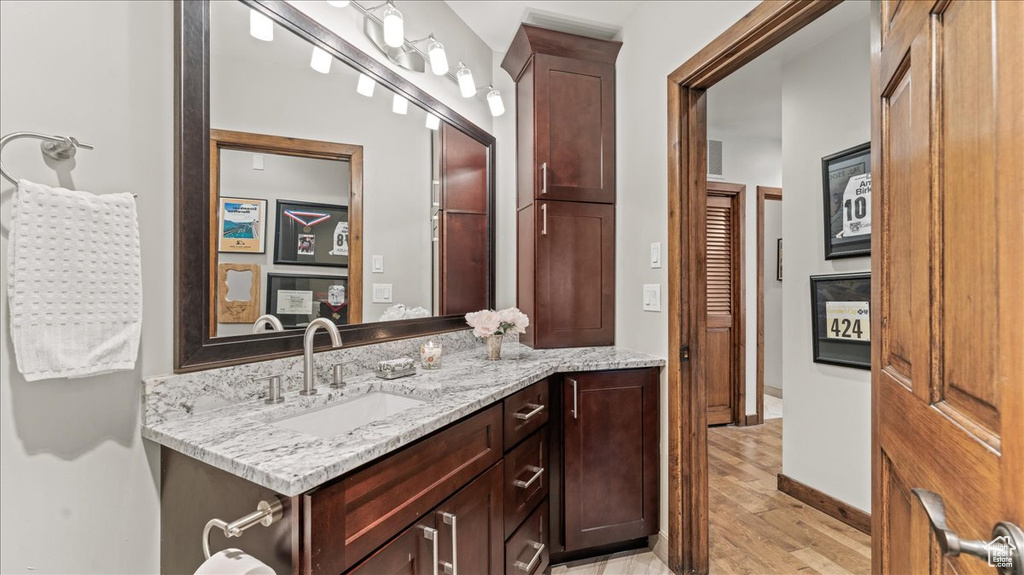 Bathroom featuring wood finished floors, vanity, and baseboards
