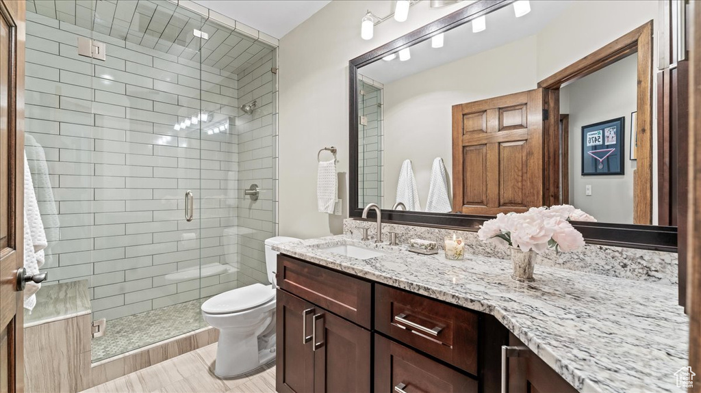 Full bath with vanity, a shower stall, and toilet