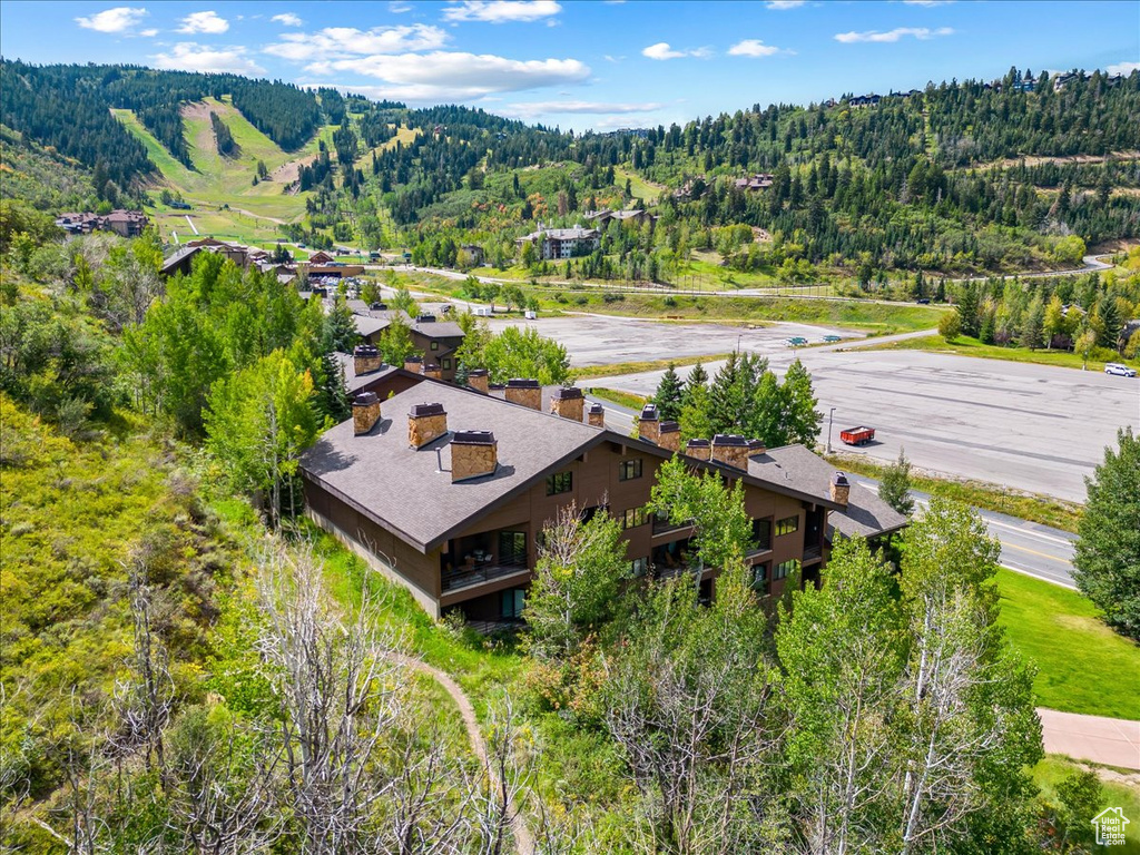 Aerial view of property and surrounding area with a heavily wooded area