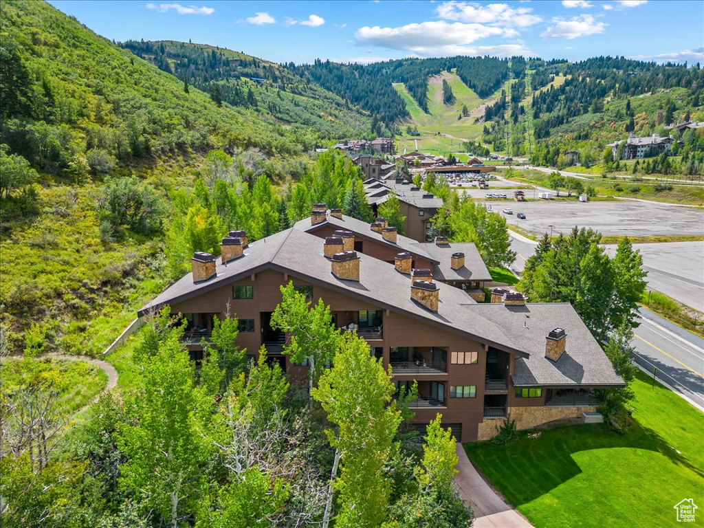 View from above of property featuring a heavily wooded area and a mountainous background