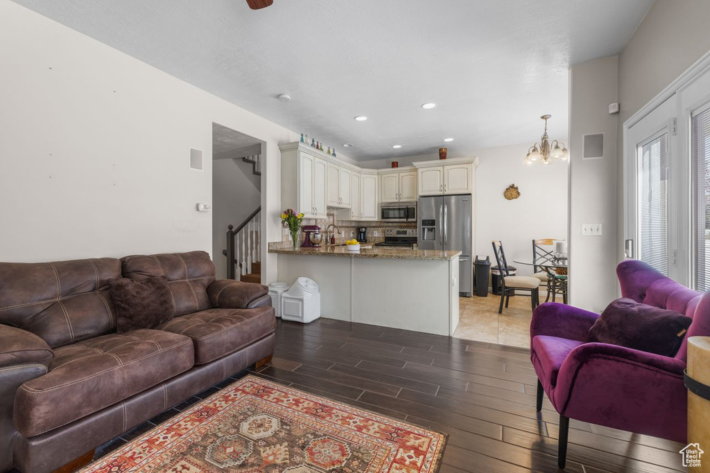 Living area with visible vents, a notable chandelier, stairway, recessed lighting, and light wood-style flooring