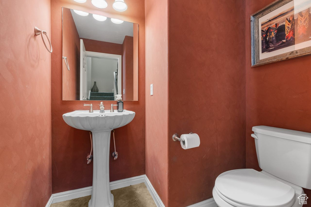 Half bathroom featuring toilet and baseboards