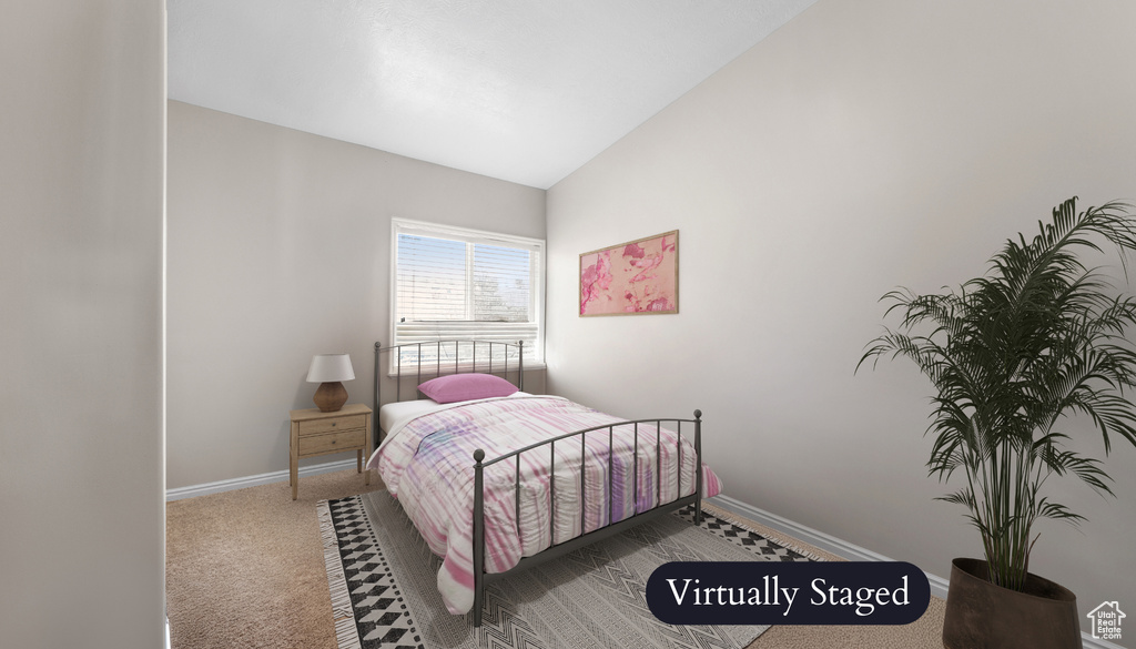 Bedroom featuring lofted ceiling and carpet