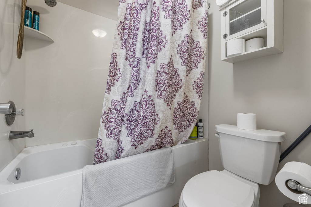 Full bathroom with shower / tub combo with curtain and toilet