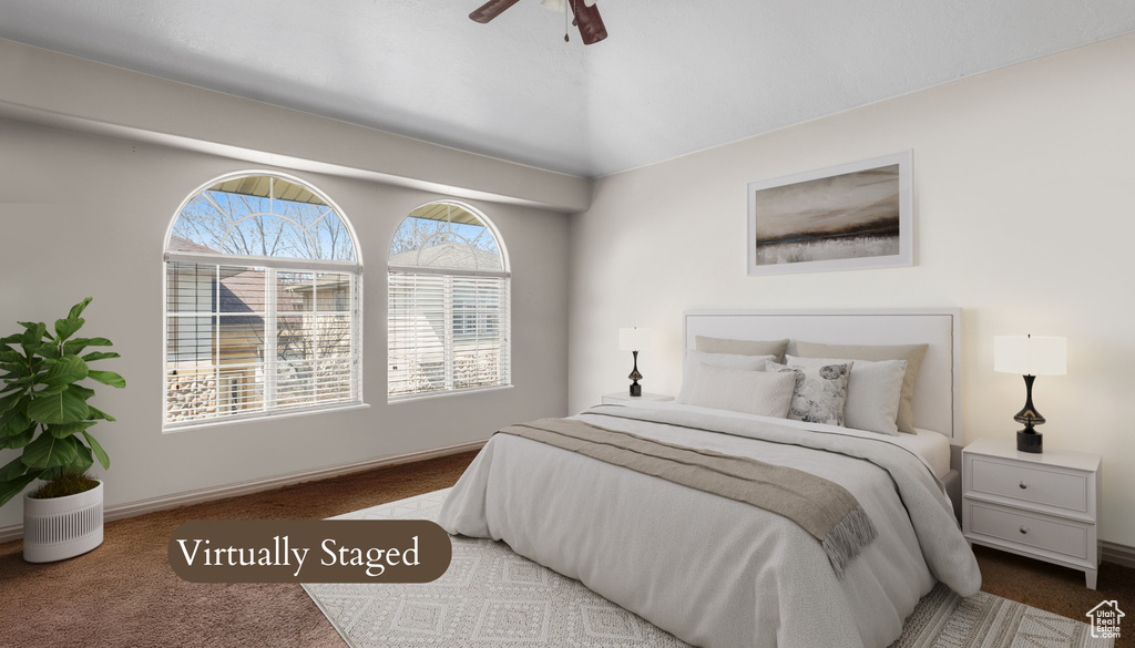 Bedroom with carpet, baseboards, ceiling fan, and vaulted ceiling