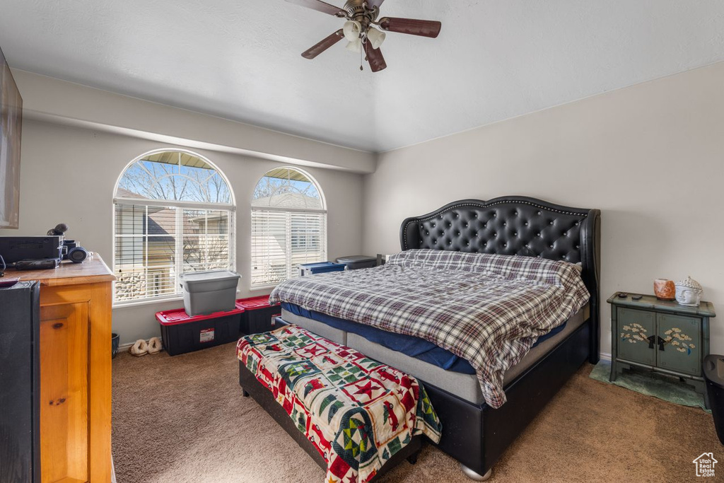 Carpeted bedroom featuring a ceiling fan
