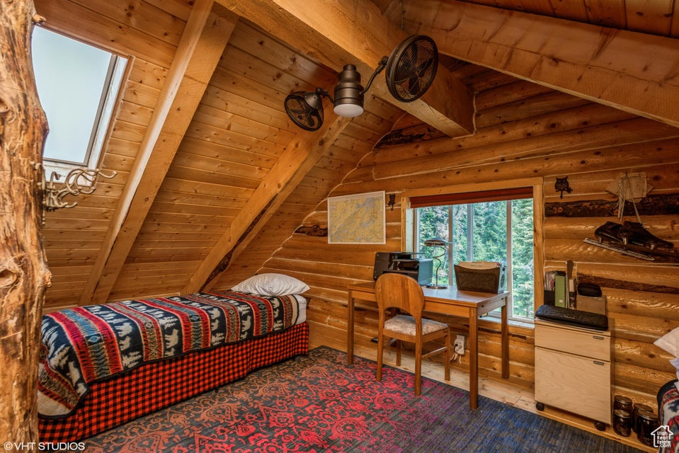 Bedroom featuring wood ceiling and rustic walls