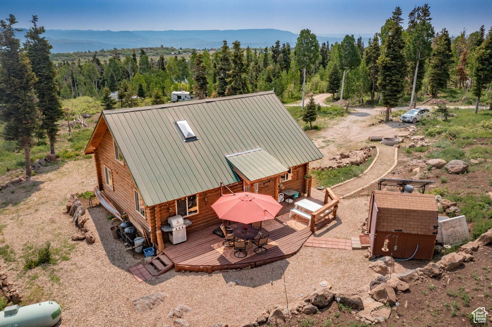 Aerial view of property and surrounding area featuring a forest